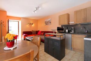 a kitchen and living room with a table and a couch at Très bel appartement 4 pers Chalet Les Lupins - Les 2 Alpes in Les Deux Alpes