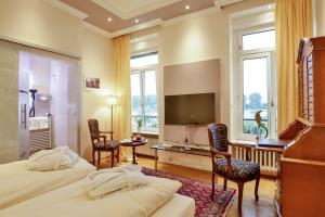 ein Hotelzimmer mit 2 Betten und einem Flachbild-TV in der Unterkunft Rhein-Hotel Nierstein in Nierstein