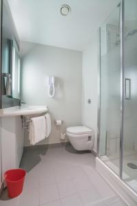 a white bathroom with a toilet and a shower at Ibis Setif in Sétif
