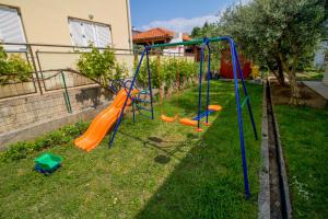 a playground in the yard of a house at Rooms & Apartment Albina in Baška