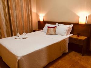 a bedroom with a large bed with white sheets and pillows at Hotel Portinari in Porto