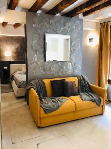 uma sala de estar com um sofá amarelo em frente a uma parede em Suite Dream on the River em Veneza