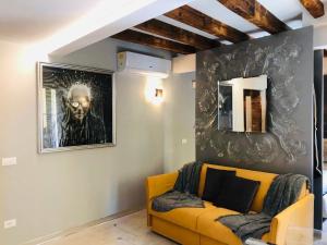 uma sala de estar com um sofá amarelo e um quadro em Suite Dream on the River em Veneza
