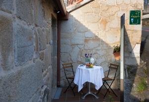 a table in an alley with a white table cloth at Casa A Marchanta in Poio