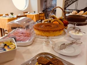 a table with a cake and other food on it at Hotel Portinari in Porto