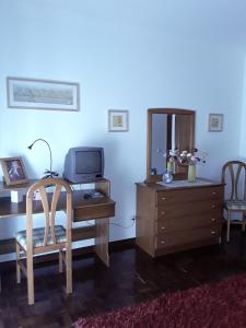 a room with a desk with a tv and a dresser at Villa Ciriaco Sea Star in Ericeira