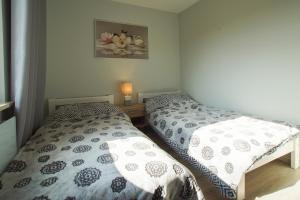 a bedroom with two beds and a picture on the wall at Magnolia in Wilków