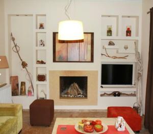 a living room with a fireplace and a tv at Eirini's House Corfu in Kynopiástai