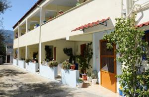 a building with potted plants on the side of it at KOTSIFAS ROOMS in Tyros