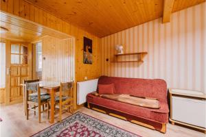 a living room with a red couch and a table at Wędrowiec in Karwia