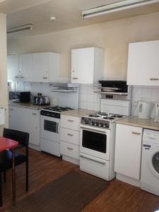 a kitchen with white appliances and a red table at The Crystal Lodge Hotel in Croydon