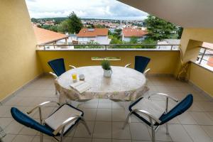a table and chairs on a balcony with a view at Apartman Sintić in Krk