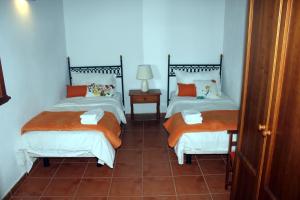 two twin beds in a room with a tiled floor at Mama Yé in Lodero