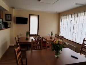 a dining room with tables and chairs and a window at Casa Munte Busteni in Buşteni