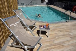 eine Frau, die in einem Pool mit einem Kind im Wasser schwimmt in der Unterkunft Hotel Adler in Alassio