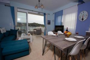 a blue living room with a table and a blue couch at Seaside Apartments in Kaloi Limenes