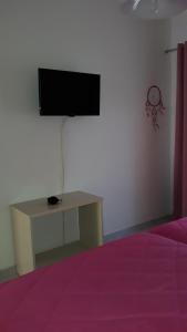 um quarto com uma televisão numa parede com uma mesa em Laloudaki Apartments em Tyros