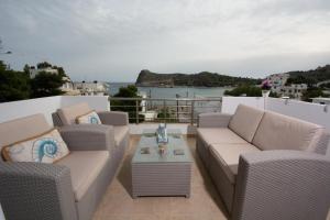 um pátio com cadeiras e uma mesa e o oceano em Seaside Apartments em Kaloí Liménes