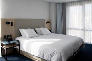 a bedroom with a large white bed and a window at Casa Grande Express in La Paz +26 photos