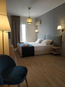 una camera d'albergo con letto e sedia di Lilly Apartments ad Atene