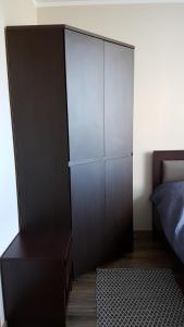 Apartament Prima في ريدا: غرفة نوم مع خزانة بنية كبيرة بجوار سرير