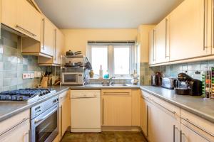 a kitchen with a sink and a stove top oven at Central & stylish 3 bedroom, 2 bath, free parking in Edinburgh