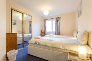 een slaapkamer met een groot bed en een spiegel bij Central & stylish 3 bedroom, 2 bath, free parking in Edinburgh
