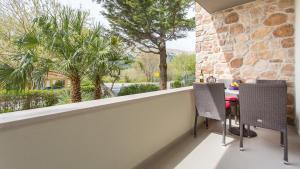 a balcony with a table and two chairs and a window at Apartmani Memories I in Baška