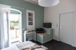 a bedroom with a bed and a television and a window at Casamata in Ragusa