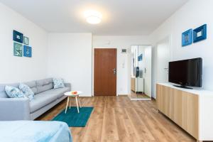 a living room with a couch and a tv at Sleepway Apartments - Blue Dream in Poznań