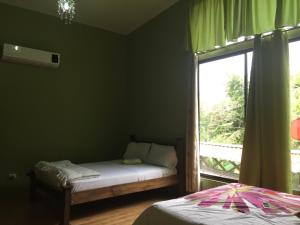 a bedroom with a bed and a window with a view at Casa Playa Bahia Ballena de Osa in Uvita