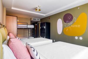 a room with two beds and a wall with a mural at Selina Lapa Rio de Janeiro in Rio de Janeiro