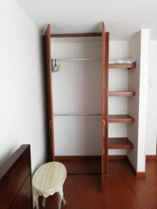 um quarto com um armário com uma escada e um banco em Habitación con baño privado em Tunja