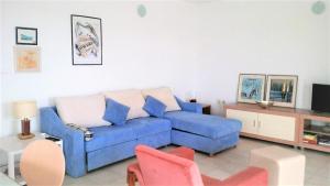 a living room with a blue couch and chairs at Vila Rosa in Sevid