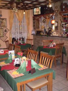 un restaurant avec des tables et des chaises vertes et un tissu de table vert dans l'établissement Pension a Restaurant VESNA - České Švýcarsko, à Srbská Kamenice