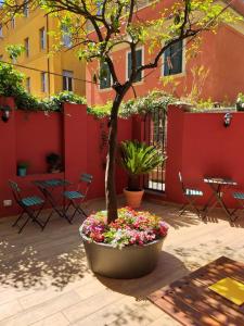 a tree in a pot with flowers in a courtyard at Casa in Monti in Rome