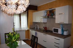 a kitchen with white cabinets and a table and a chandelier at casa belvedere in Monzambano