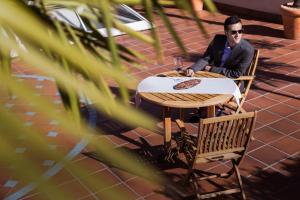 a man sitting at a table with a glass of wine at Pullman Madrid Airport & Feria in Madrid