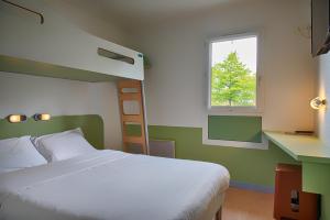 - une chambre avec un grand lit et une fenêtre dans l'établissement ibis budget Redon, à Redon