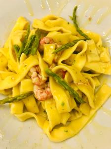 a pasta dish with shrimp and asparagus on a plate at Hotel Della Baia in Portovenere