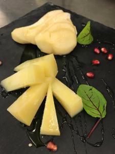 a black plate with cheese and pomegranates on it at Hotel Della Baia in Portovenere