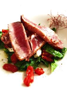 a plate of food with meat and vegetables on it at Hotel Della Baia in Portovenere