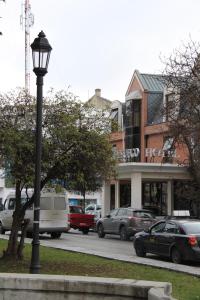 una luz de la calle con coches estacionados frente a un edificio en Hotel Tierra Del Fuego, en Punta Arenas