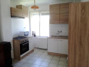 a kitchen with white cabinets and a window at Bochmann Cottage in Zalaszántó