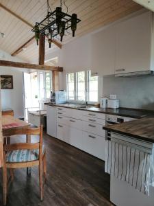 a large kitchen with white cabinets and a table at Niesenblick in Aeschlen ob Gunten