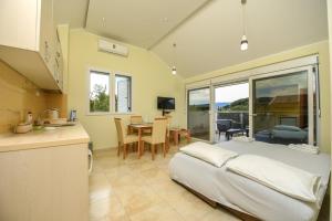 a bedroom with a bed and a kitchen with a table at Sea Point II Apart hotel Tivat in Tivat