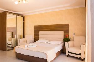 ガグラにあるMini-Hotel Mys Nadezhdaのベッドルーム1室(大型ベッド1台、椅子2脚付)