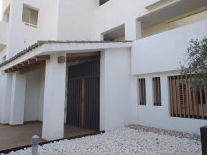a white house with a black door and a courtyard at Alamar Cala Mijas Sun&Beach in La Cala de Mijas