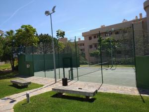 a tennis court with a bench on a tennis court at Alamar Cala Mijas Sun&Beach in La Cala de Mijas