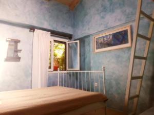 1 dormitorio con cama y ventana en Corfu Town Garden Cottage en Corfú